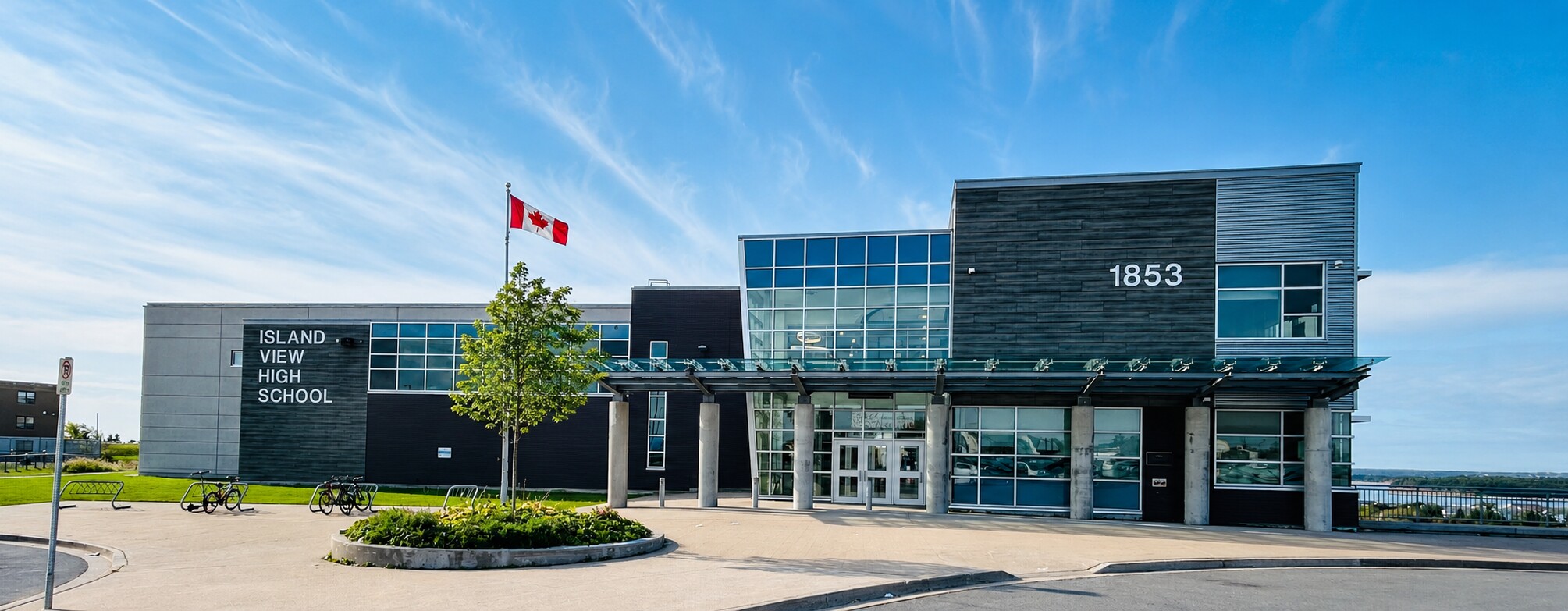 Front exterior of Island View High School, with a Canadian flag flying above the main entrance.
